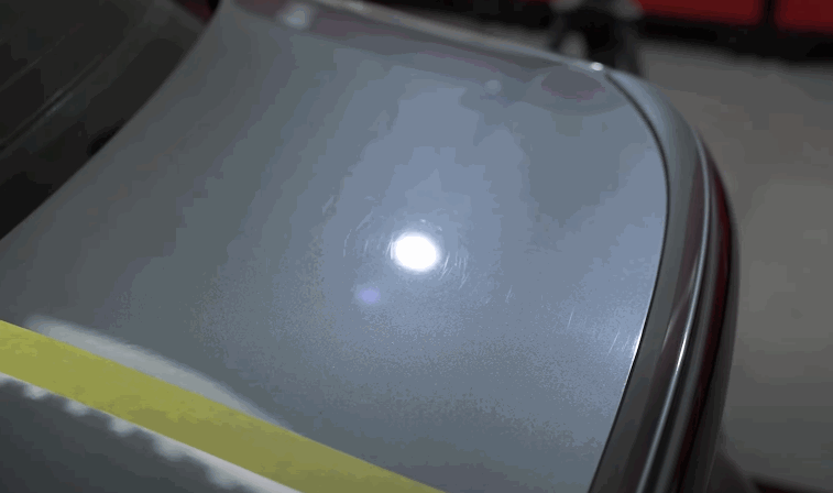 Car panel under bright inspection light showing swirl marks before ceramic coating application in Chesterfield, MO.