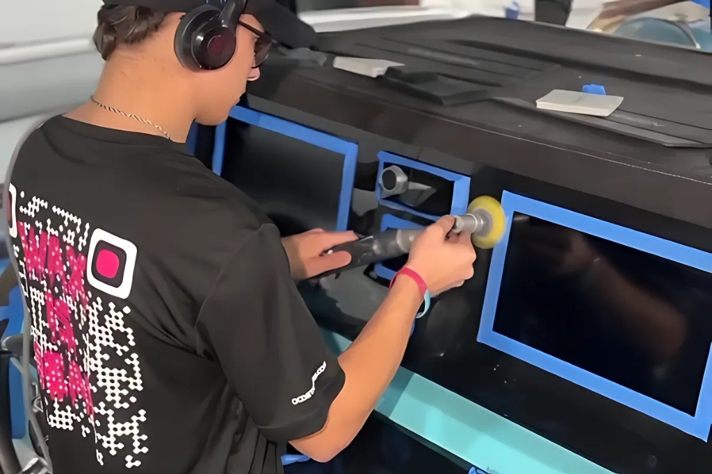 A detailer wearing headphones uses a polishing machine on a taped-off boat dashboard, preparing the surface for marine ceramic coating application to ensure long-term protection and finish quality.